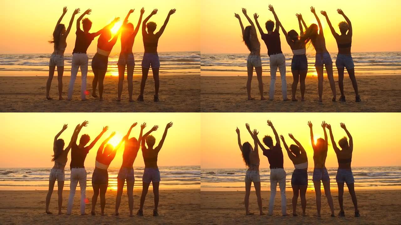 一群快乐的人坐在空旷的日落海滩上，向太阳挥手致意
