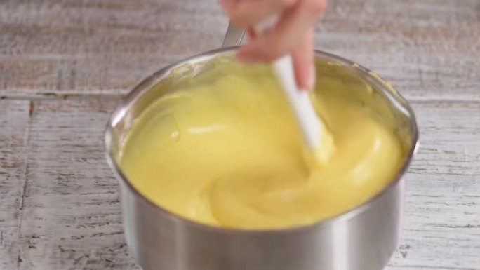 奶油冻的特写正在锅中搅拌。