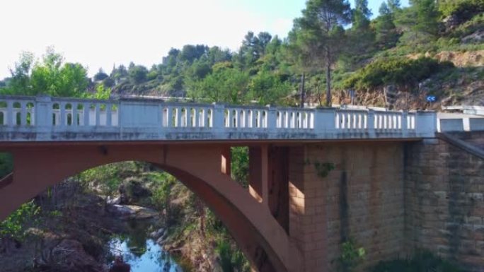 无人机视频在绿色森林中，河流和弧形桥梁。