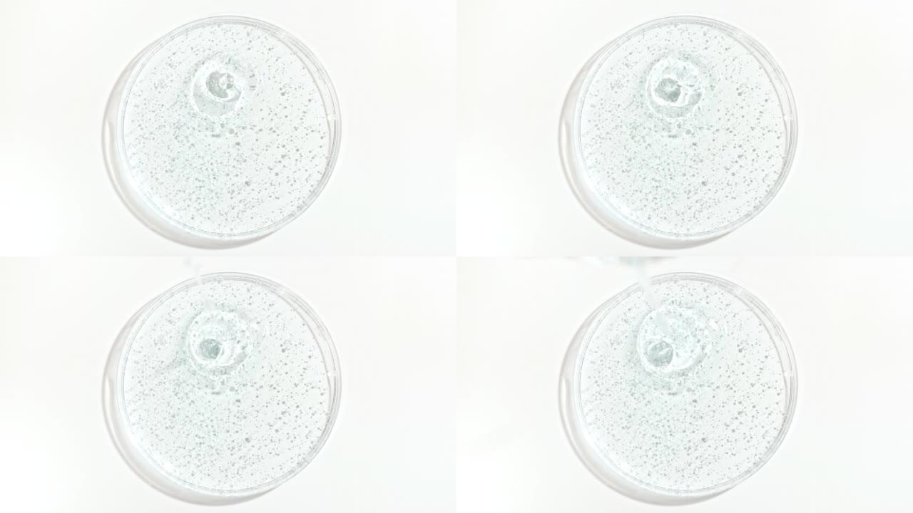 透明化妆品凝胶液滴入Petri的玻璃碗中。化妆品血清、透明质酸的宏观注射。概念护肤。
