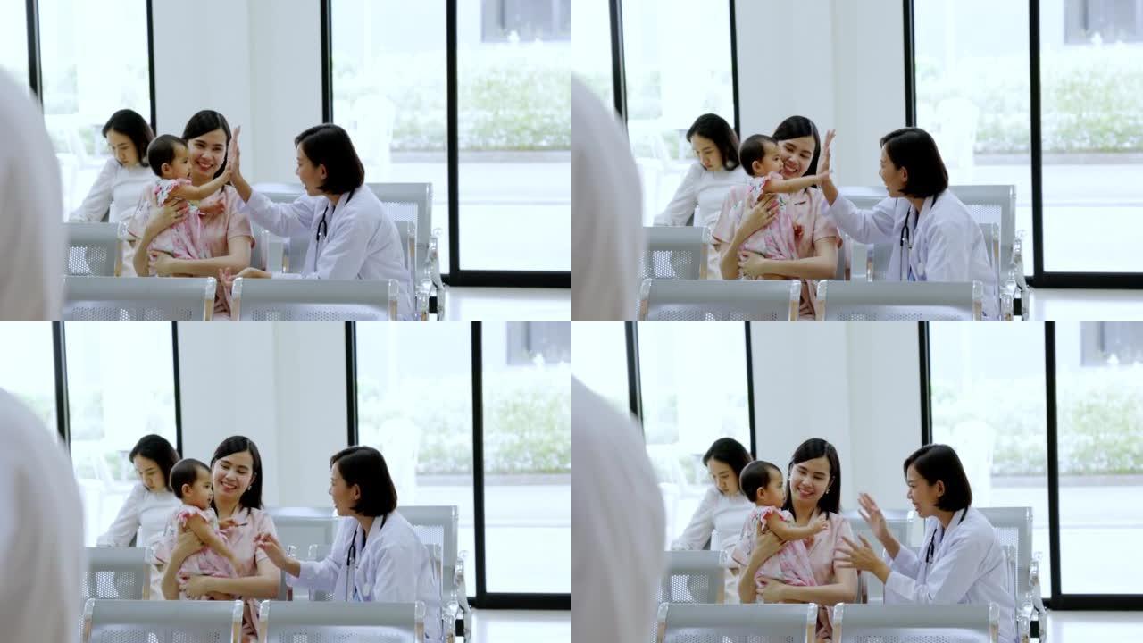 亚洲父母带他们可爱的女儿去诊所看医生。儿童保健。儿童健康检查。母亲照顾蹒跚学步的孩子。