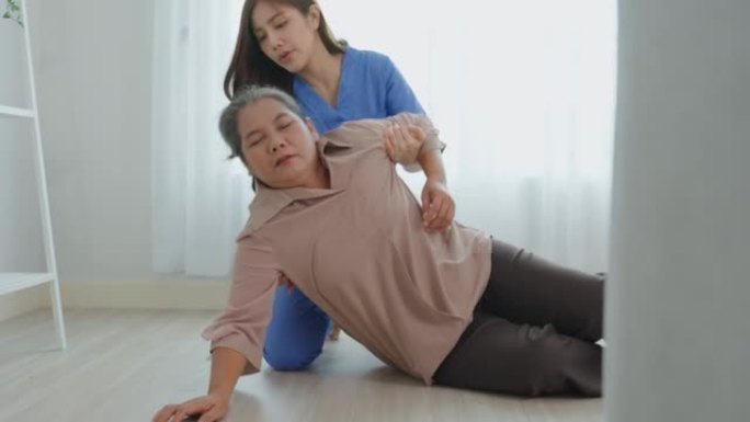 亚洲照顾者帮助老年妇女避免在家中摔倒。老年老年患者在接受物理治疗后发生事故，然后在客厅被有吸引力的治