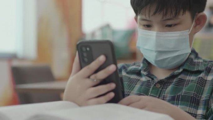 新常态，亚洲男孩脸看手机，科技教育在线