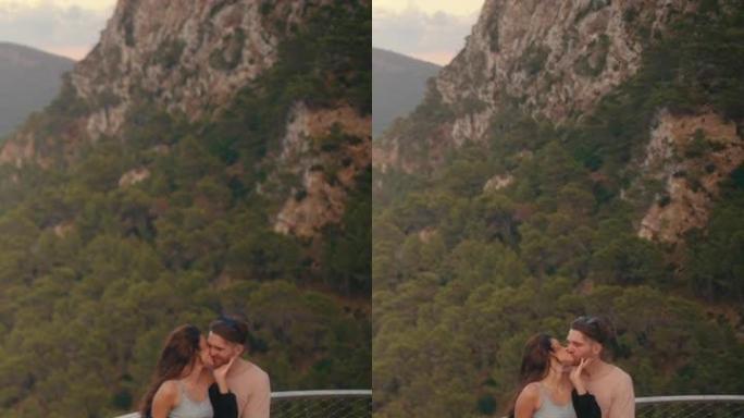 浪漫的夏天。夫妇在度假时参观一个景点，观看下面的风景。接吻垂直视频
