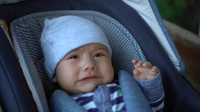 一个刚出生的婴儿躺在婴儿车里哭泣。这孩子不舒服。