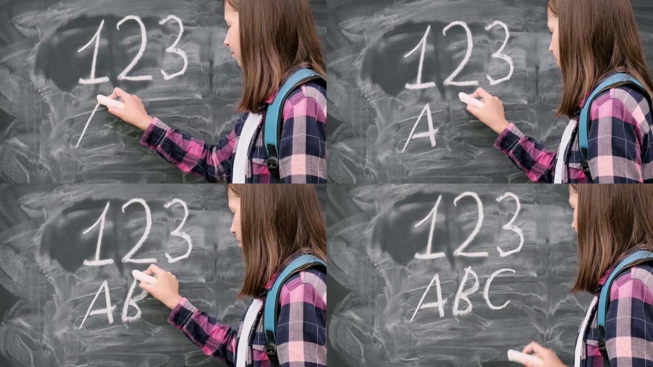 十几岁的学生女孩，穿着蓝色背包，用粉笔数字和字母写在黑色黑板背景上。教育，回到学校和人们的观念。黑板