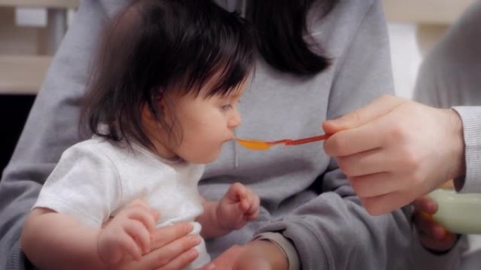年轻的父母给宝宝提供健康食品，宝宝的第一份食物