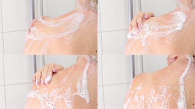 一个女人在淋浴的泡沫中洗。特写