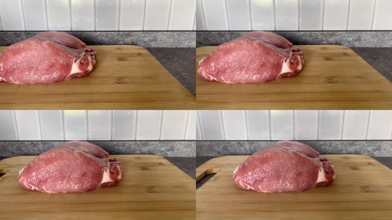 鲜肉特写，猪肉放在木板上。烹饪健康天然食物的成分。商店或餐馆的食物背景。
