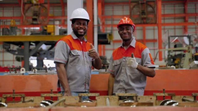 在工业工厂的生产线上做工程师、电工的工人，对工业标准充满信心地微笑着。