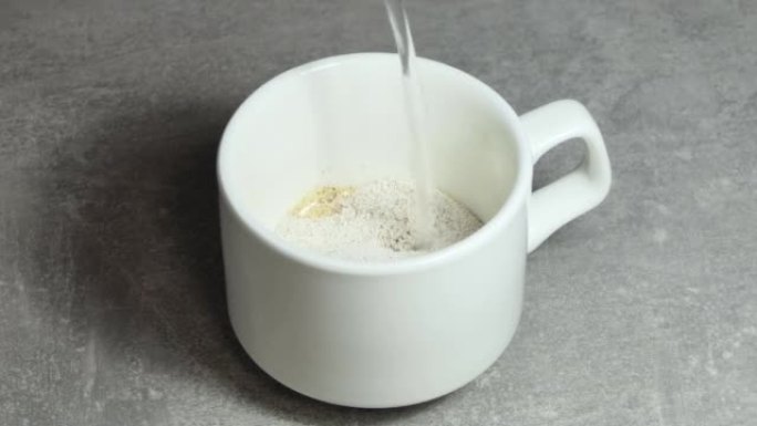 将速溶咖啡颗粒倒入白色杯子中，然后倒入开水，并在上面撒上巧克力。速溶咖啡。
