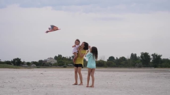 幸福家庭玩风筝户外妈妈带两个孩子女孩女儿-姐姐牵着线小宝宝坐在肩膀上