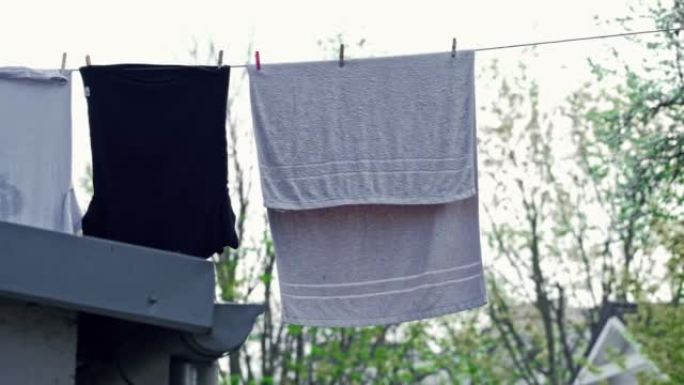 室外洗衣线上的湿衣服和毛巾烘干