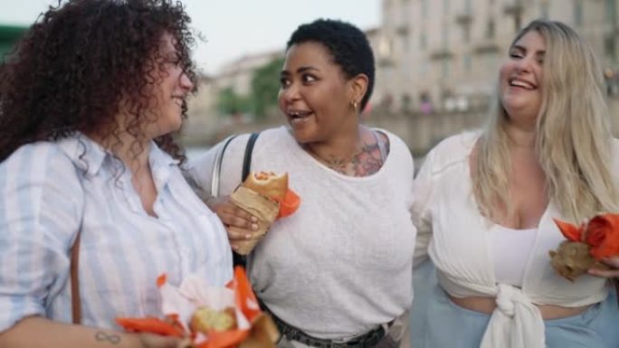 Friends eating fast food on the street