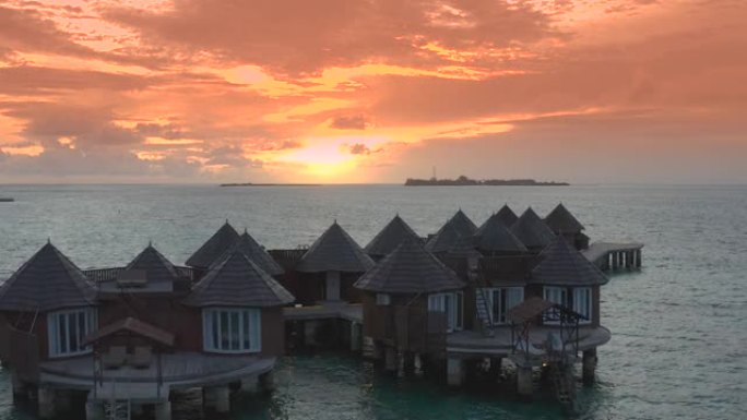 当时的水上别墅在热带海洋和珊瑚礁中令人惊叹的日落。空中无人机视图。
