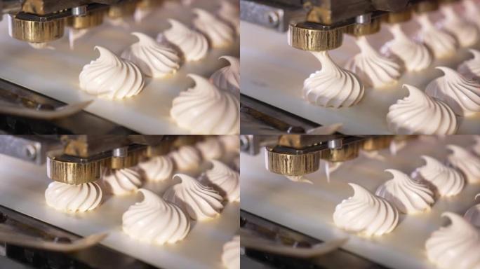 白色奶油棉花糖被挤压在移动的传送带上。特写。甜品制造自动化生产线。糖果概念。