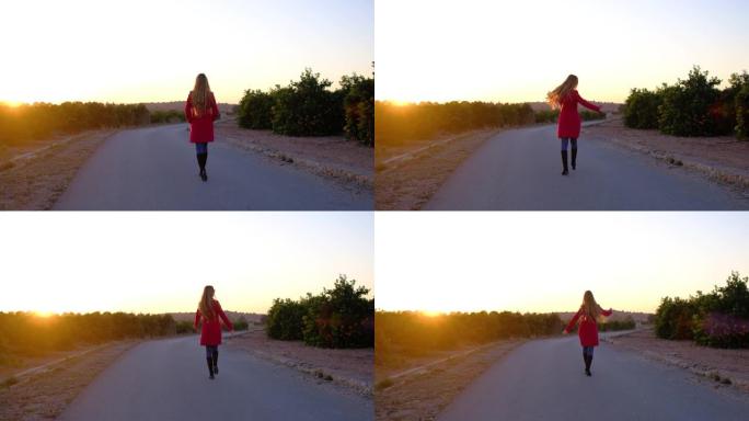 穿着红色外套的女人在金色的日落时分在道路上跳跃。