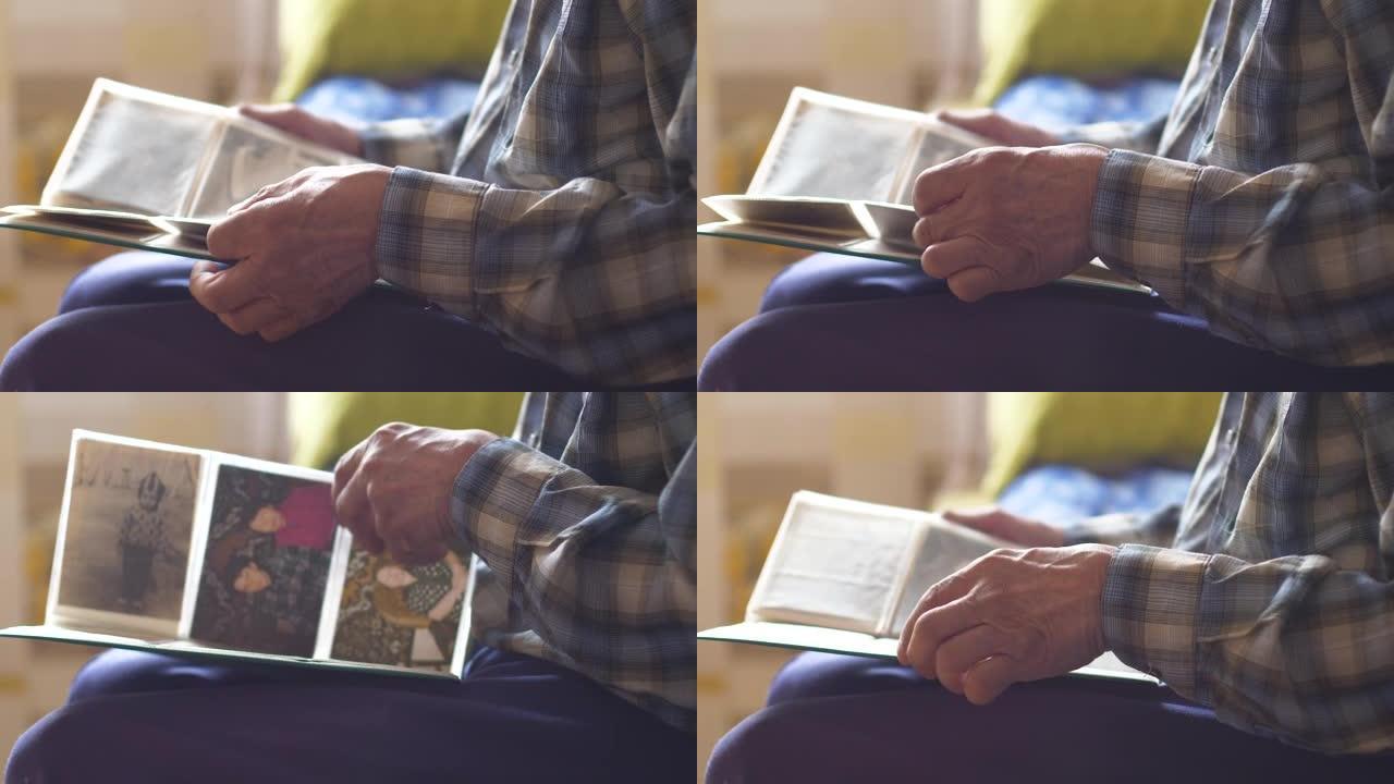 一位老人翻阅家庭相册，里面有房子的旧照片。过去的回忆和他一生的回忆。在养老金领取者手中，一本家庭相册