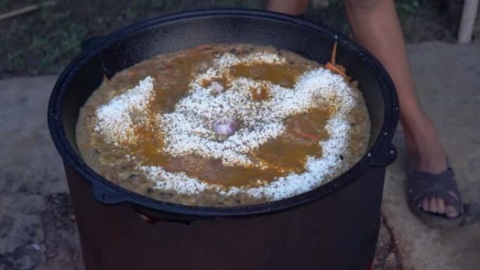 在大锅中火上煮抓饭。东方菜，米饭和肉。