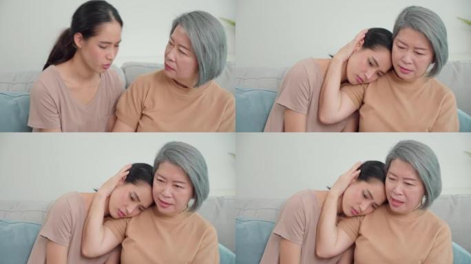 亚洲女儿与母亲坐在客厅沙发上感到压力和悲伤。女人的绝望和遗憾的情绪。