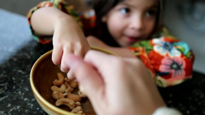 小女孩吃碗里的腰果孩子吃健康的零食