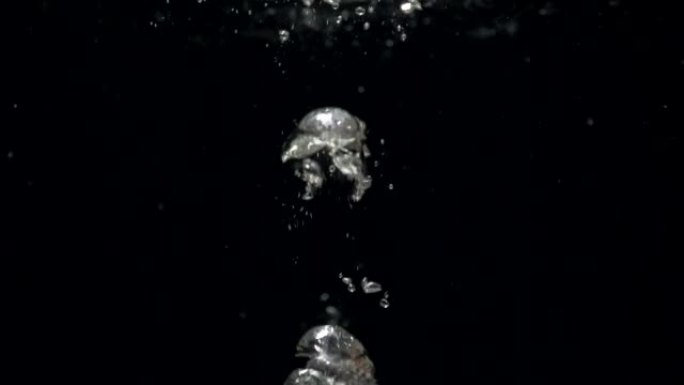 水中的慢动作气泡上升到黑色背景上的表面