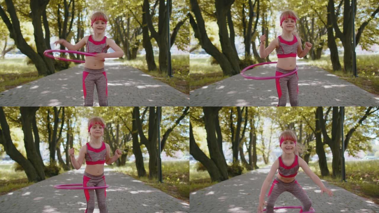 运动健身蹒跚学步的女孩训练在公园里玩扭转呼啦圈圈环