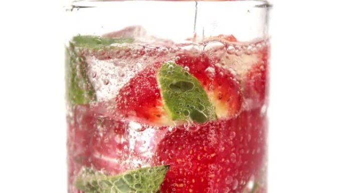 倒纯水流饮用玻璃草莓薄荷泡泡鸡尾酒变慢孤立