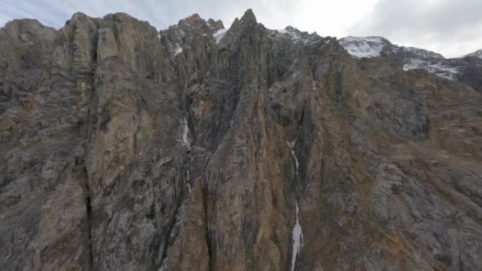 鸟瞰图天然山地冰川纹理形成雪峰云景。4k FPV运动无人机荒野悬崖环境尖峰地质岭冬季海拔全景