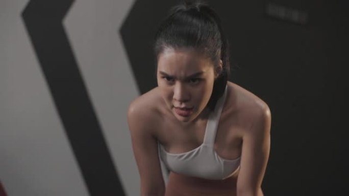 亚洲女性汗流浃背，厌倦了斗绳练习。