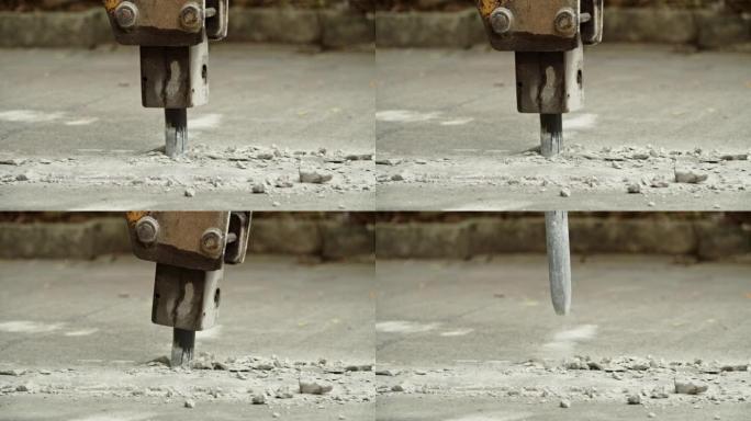 在混凝土路面上工作的挖掘机液压臂碎石机的特写