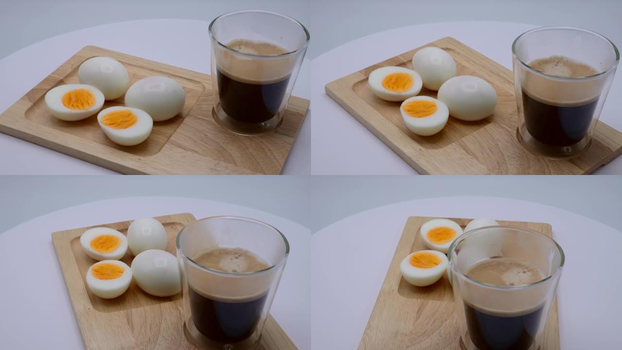 水煮蛋和杯黑咖啡在木制托盘旋转 ..