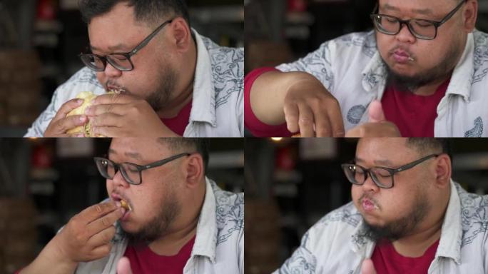 胖乎乎的年轻人拿着一口汉堡咬了一口。