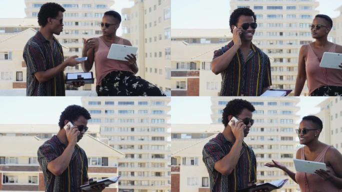 屋顶上有数字平板电脑和智能手机的年轻商人