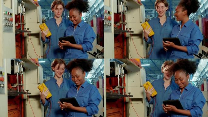 两名面带微笑的工程师女工穿着安全服，站在机器附近，拿着数字平板电脑，用工业工厂的检流计记录、检查和检