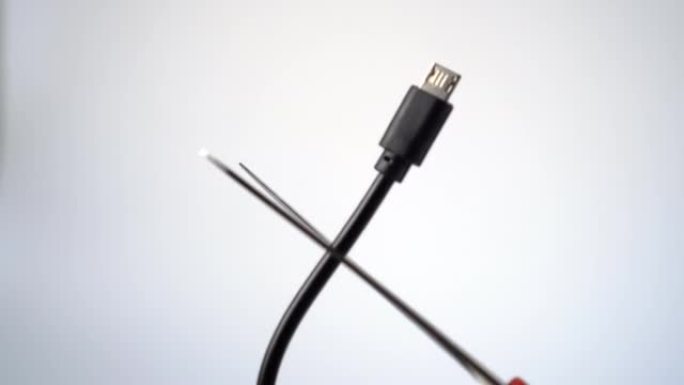 剪刀切割黑色微型USB电缆特写。充电修理