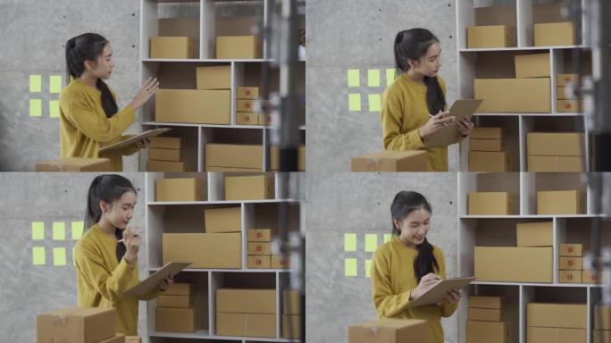 创办一个中小企业，一个独立的亚洲女性使用带盒子的笔记本电脑的小企业企业家。快乐的成功女人从事在线营销