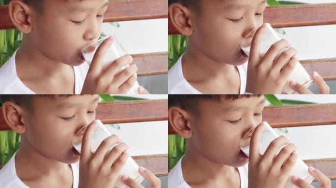 亚洲男孩早餐一杯新鲜牛奶。