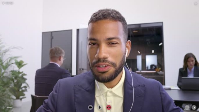 LD年轻的混血儿男人坐在办公室里，在视频会议上聊天，屏幕上可以看到视频区域的图形