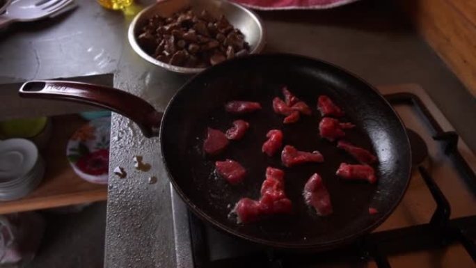 慢动作特写烹饪小片红肉锅里溅油a