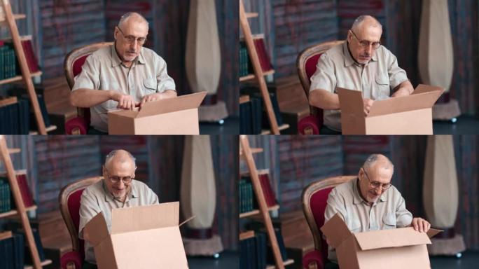 微笑成熟的70年代祖父打开包裹纸板箱网上商店订单送货乡村家居