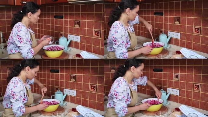女厨师糖果用木勺搅拌撒上糖的红醋栗，准备自制果冻