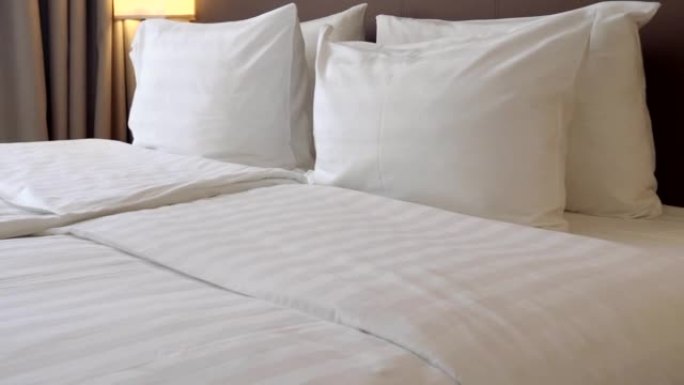 酒店舒适的双人房，配有枕头和折叠床上用品，通过视频4k分辨率