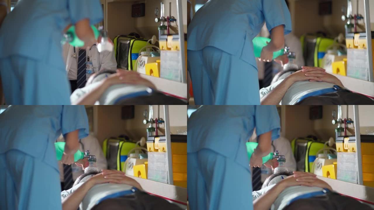 EMS护理人员团队在转移到医院期间帮助救护车中的受伤患者。手持复苏袋有助于在紧急情况下呼吸。事故和医