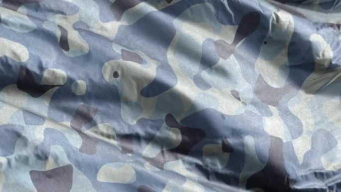 蓝军迷彩纺织面料在风中缓缓飘扬。海军军用迷彩服装质感。全填充慢动作无缝循环。