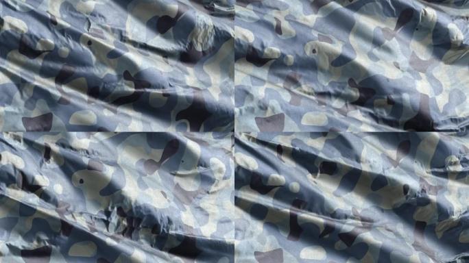 蓝军迷彩纺织面料在风中缓缓飘扬。海军军用迷彩服装质感。全填充慢动作无缝循环。