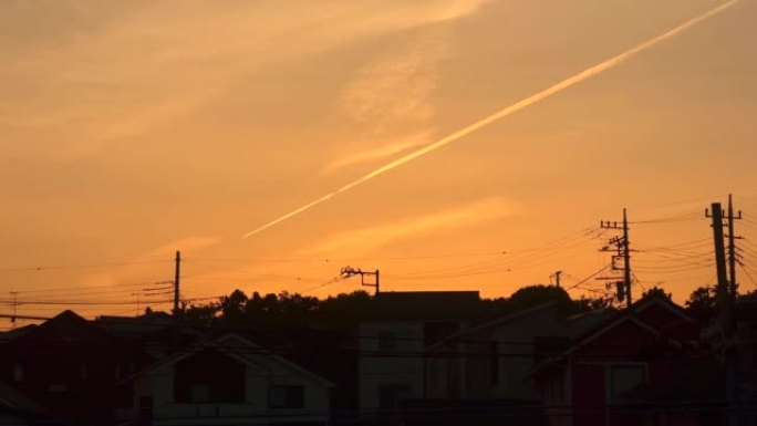 日落时居民区上空的蒸气踪迹