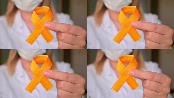 国际儿童癌症日。穿着白大褂的女医生拿着黄丝带。肉瘤意识，膀胱癌。白血病癌症意识。世界多发性硬化症日。