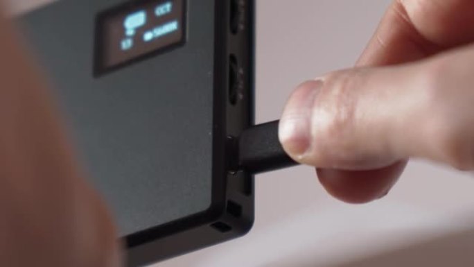 手持USB C型电缆连接或断开。选择性聚焦