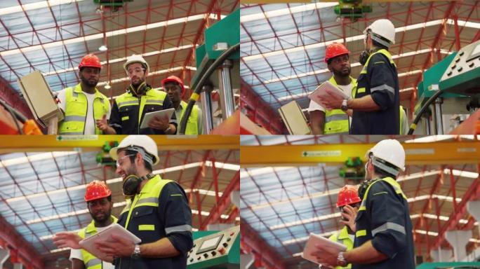 穿着制服的男工程师工作人员戴着安全安全帽，拿着平板电脑和剪贴板走路，向工业施工现场的同事解释工业工作